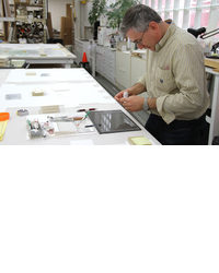 Mark Minevich hinging a work of art