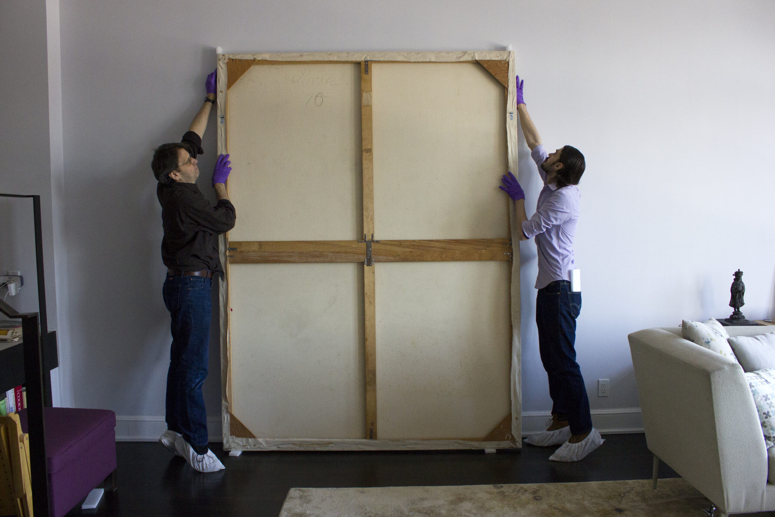 Chris and Ethan leaning painting against wall